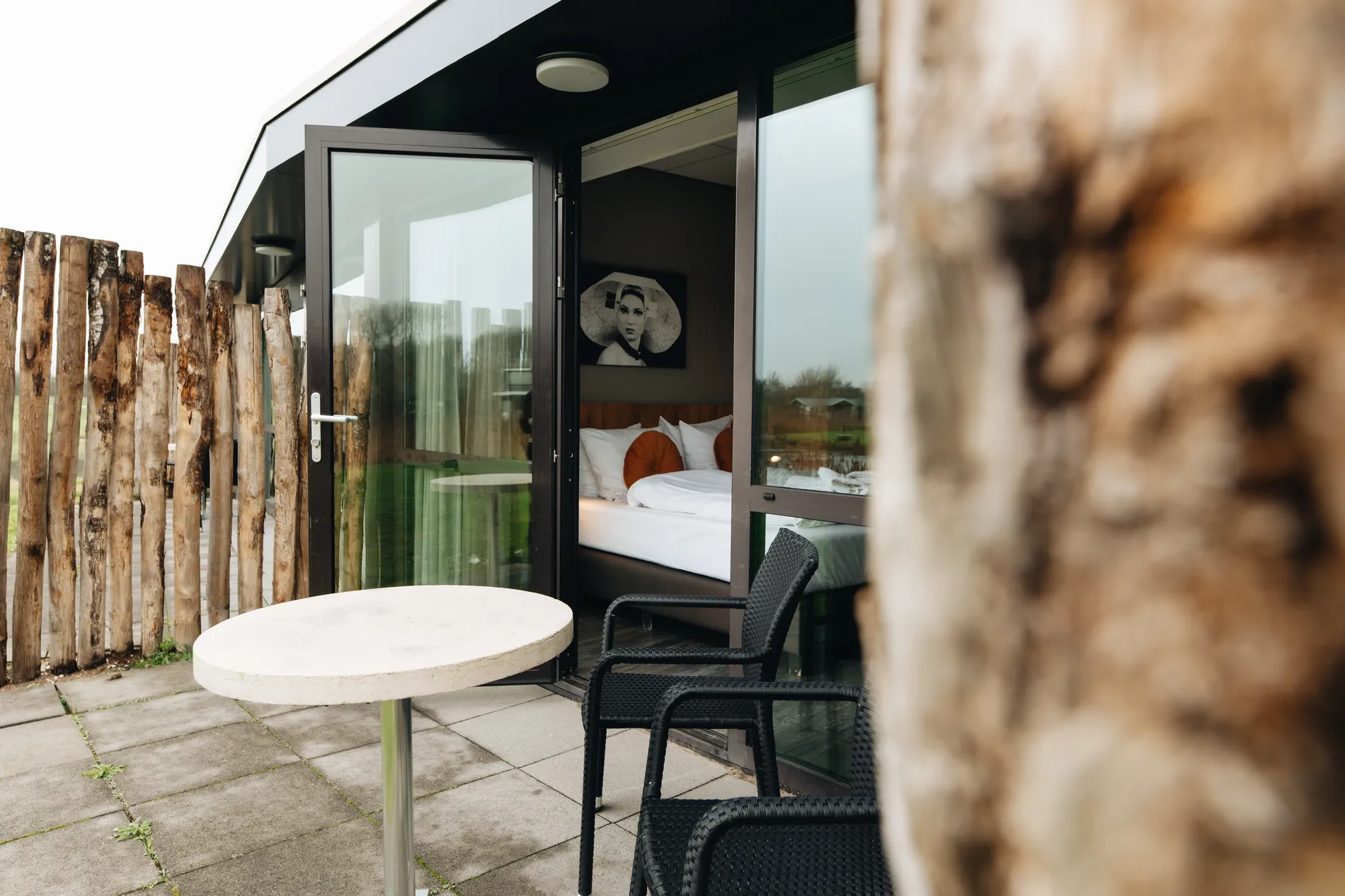 Terras van een hotelkamer bij Resort Land & Zee met modern buitenmeubilair en zicht op de duinnatuur.